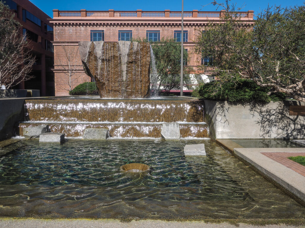 Levi Strauss Plaza fountain with cascading water over stone tiers in front of a brick office building in San Francisco.