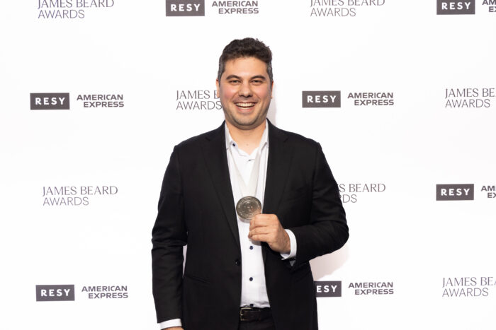 Chef Jacob Potashnick smiles while displaying his 2026 James Beard Award medal after winning Best Chef: Great Lakes. The Feld chef was recognized for his produce-driven approach and close partnerships with local farmers and producers.