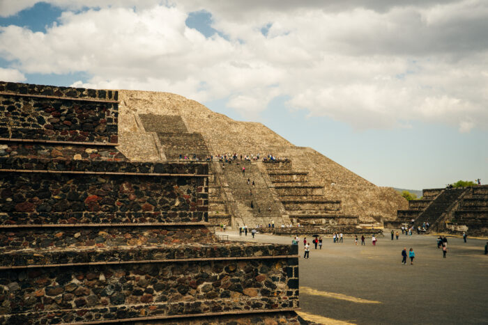 Visitors explore the stepped pyramids and stone structures of the ancient city of Teotihuacán in Mexico.
