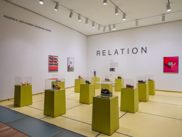 Nike sneakers displayed on yellow pedestals in the “Relation” gallery of the Nike: Form Follows Motion exhibition at the Museum of Arts and Design.