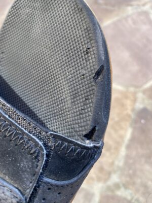Close-up of a Reef slide showing damage after becoming caught in an airport escalator.
