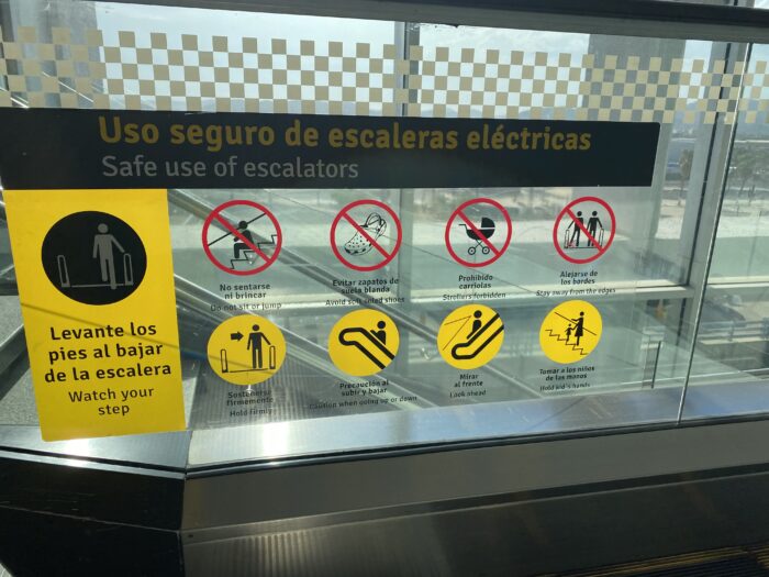Los Cabos International Airport escalator safety sign advising passengers to avoid soft-soled shoes.