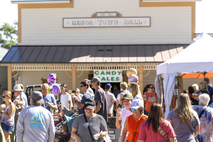 Crowds gather outside Genoa Town Hall during the annual Candy Dance, with colorful candy decorations marking the festivities.
