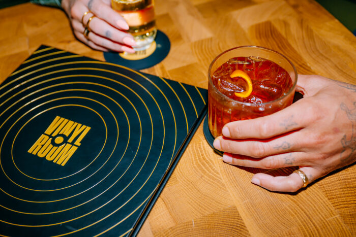 Cocktails served beside a vinyl-inspired menu at Vinyl Room.