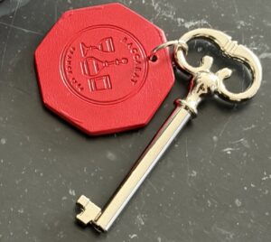 Baccarat Hotel New York guestroom key with a silver key and red leather fob embossed with the hotel logo.